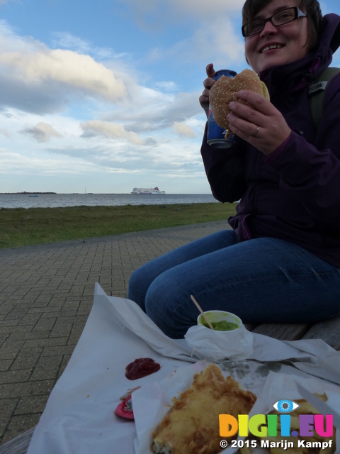 FZ019396 Jenni eating fish and chips with ferry coming in